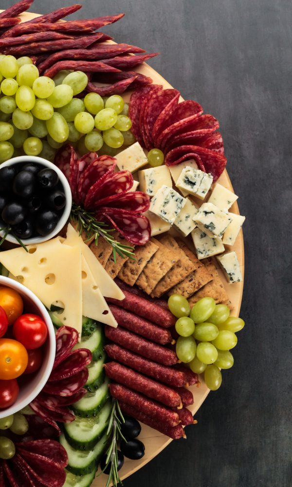 Charcuterie and cheese platter with grapes, salami, crackers, and vegetables at The Wine Shed, Market Harborough