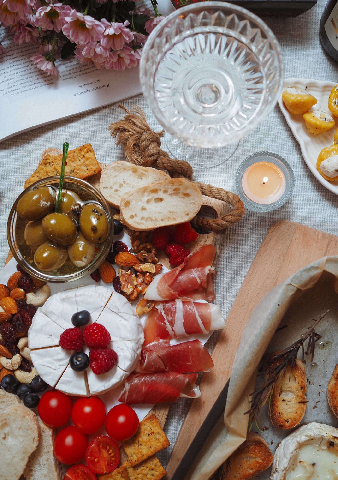 Grazing board with camembert, cured meats, olives, and wine